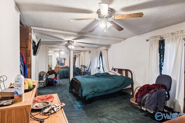 carpeted bedroom featuring ceiling fan and a textured ceiling