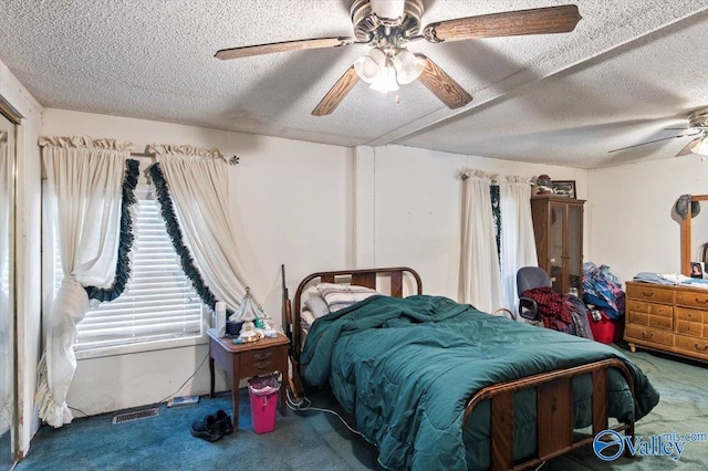 carpeted bedroom with ceiling fan and a textured ceiling