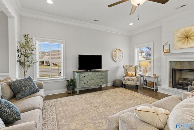 living room with ceiling fan, crown molding, a fireplace, and hardwood / wood-style floors