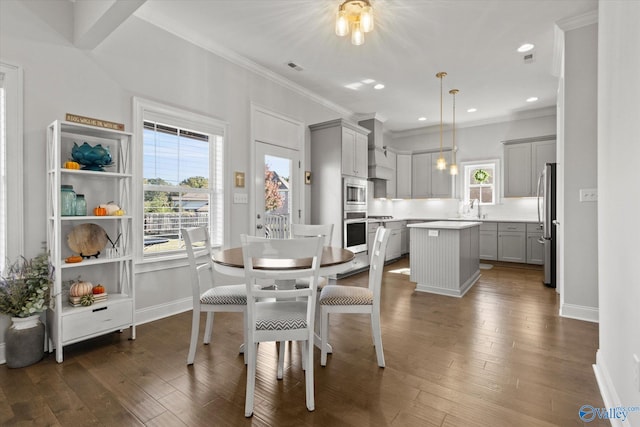 dining space featuring ornamental molding, sink, and dark hardwood / wood-style flooring