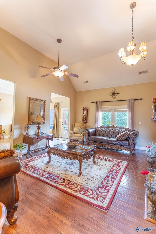 living room with wood-type flooring, ceiling fan with notable chandelier, and high vaulted ceiling