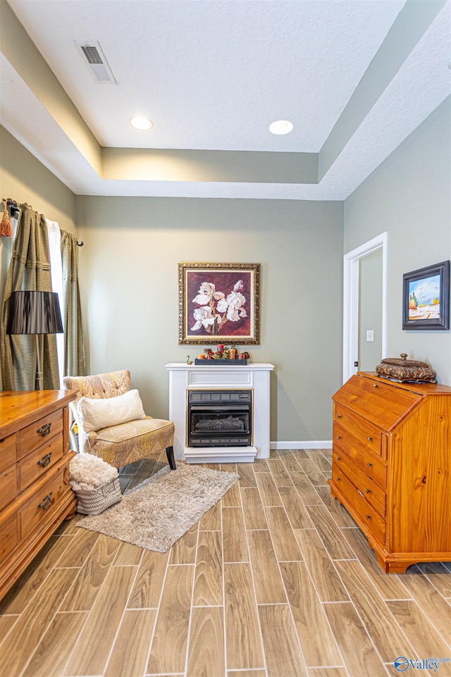 sitting room featuring a tray ceiling and hardwood / wood-style floors