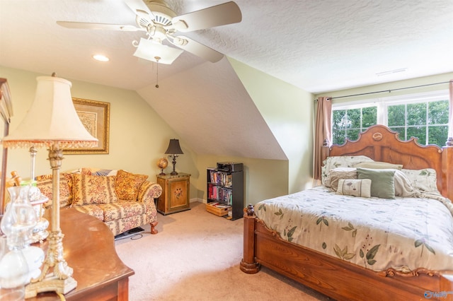 bedroom featuring light carpet, a textured ceiling, vaulted ceiling, and ceiling fan