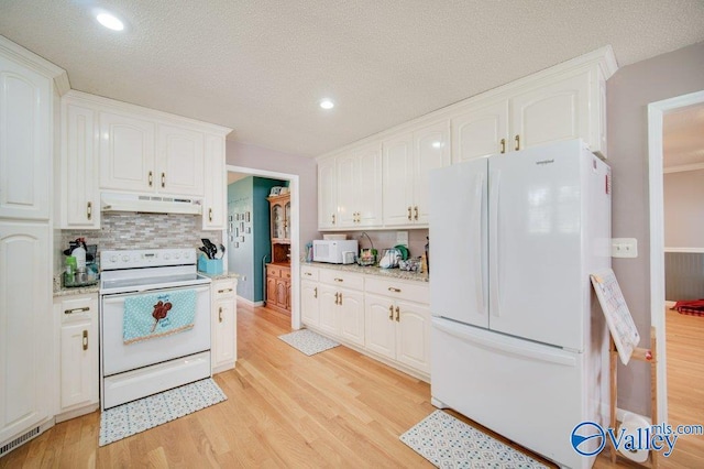 kitchen with white appliances, white cabinetry, and under cabinet range hood