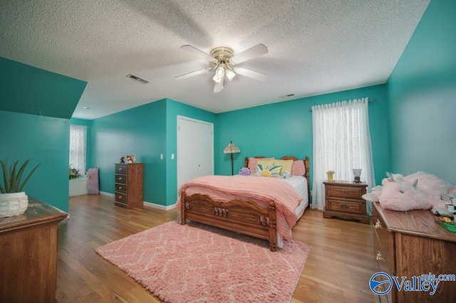 bedroom with multiple windows, wood finished floors, and visible vents