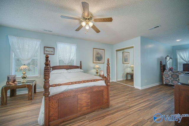 bedroom with a closet, visible vents, and wood finished floors