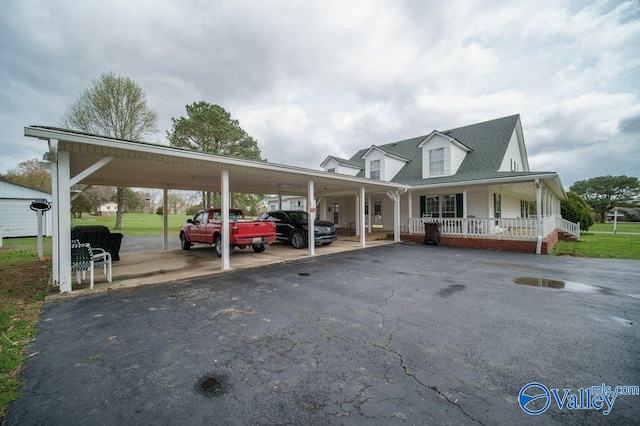 view of parking with aphalt driveway and an attached carport