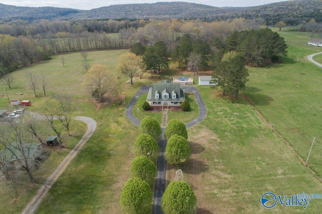 birds eye view of property with a mountain view, a view of trees, and a rural view