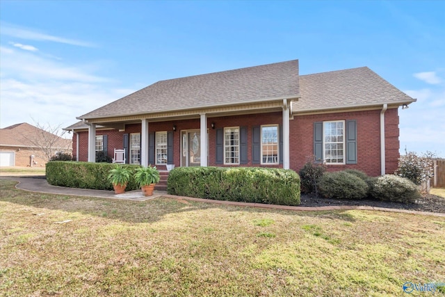 view of front facade with brick siding, a shingled roof, and a front yard