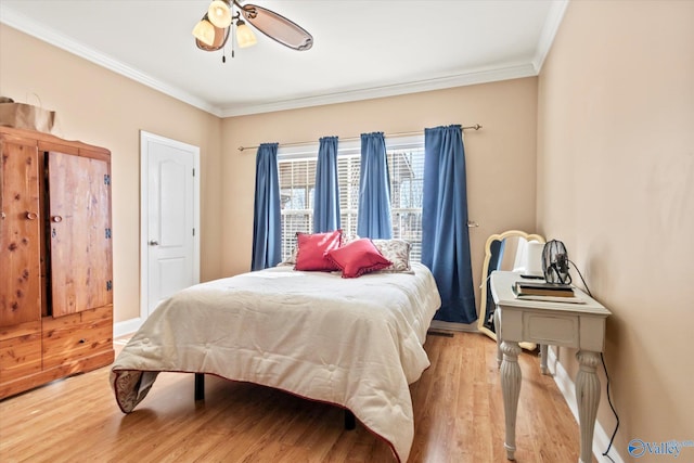 bedroom with a ceiling fan, crown molding, baseboards, and wood finished floors