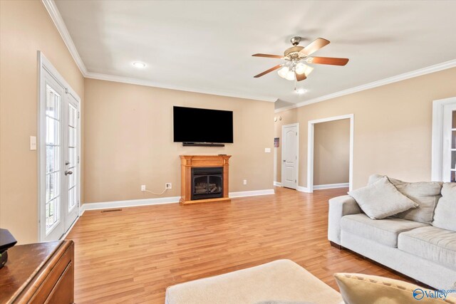 living area featuring ornamental molding, light wood-type flooring, a fireplace with raised hearth, and baseboards