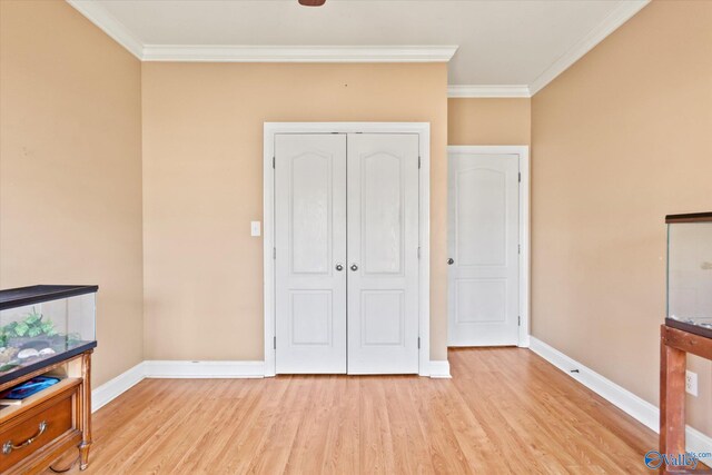 bedroom featuring light wood-style floors, a closet, baseboards, and crown molding
