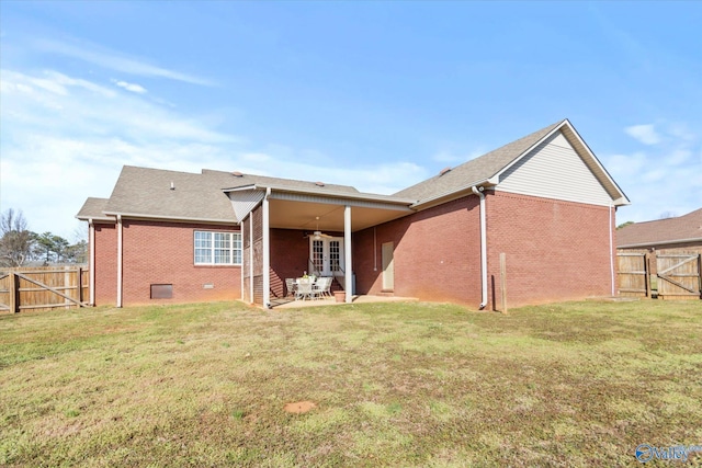 back of house featuring brick siding, a patio, a lawn, crawl space, and a fenced backyard