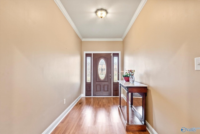 foyer featuring crown molding, baseboards, and wood finished floors