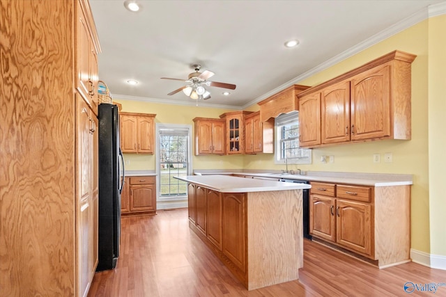 kitchen featuring crown molding, light wood-type flooring, freestanding refrigerator, and a center island