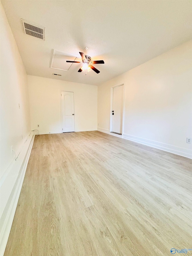unfurnished room with light wood-style floors, visible vents, baseboards, and ceiling fan