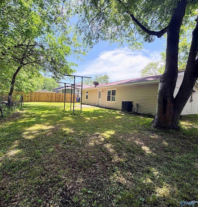 view of yard with fence and central AC