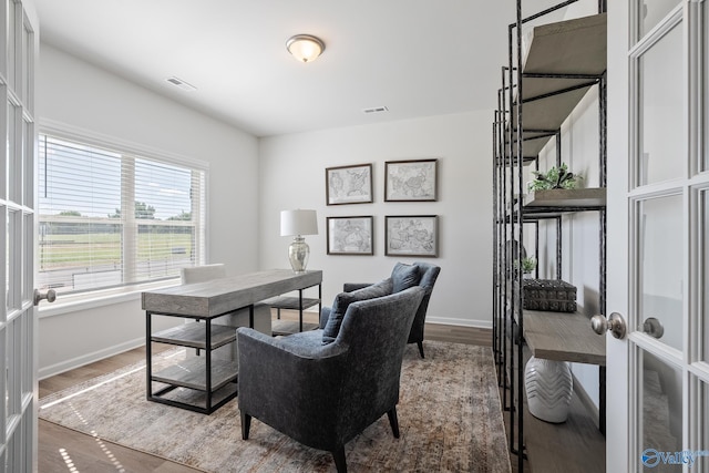 office featuring wood finished floors, visible vents, and baseboards