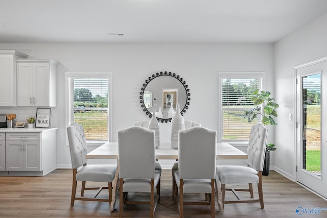 dining room with visible vents, baseboards, and light wood-style floors
