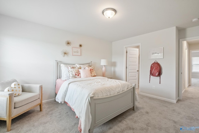 bedroom with baseboards and light carpet