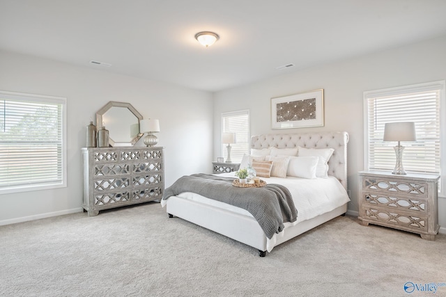 bedroom with multiple windows, visible vents, and carpet