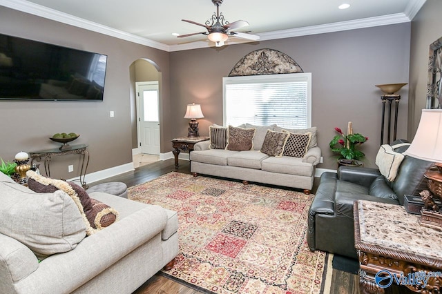 living room featuring arched walkways, ceiling fan, wood finished floors, and crown molding