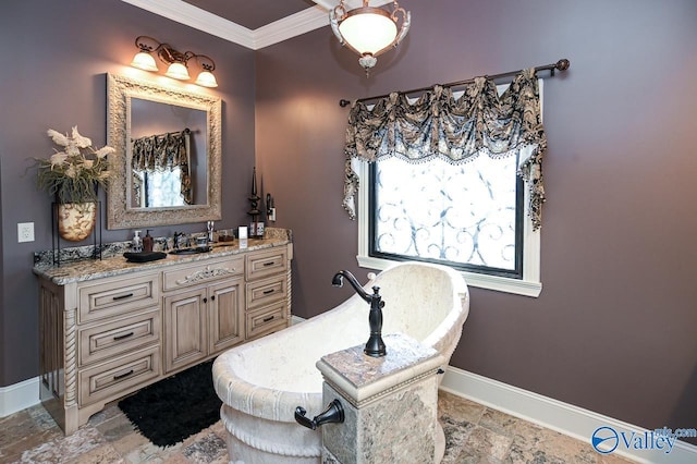 bathroom featuring a freestanding tub, vanity, stone finish floor, and baseboards