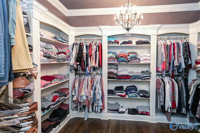 walk in closet featuring wood finished floors and a chandelier