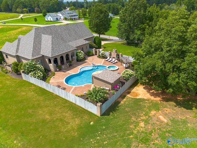 view of pool featuring a fenced backyard, a pool with connected hot tub, a patio, and a yard