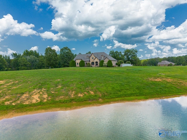 view of front of house featuring a front lawn and a water view