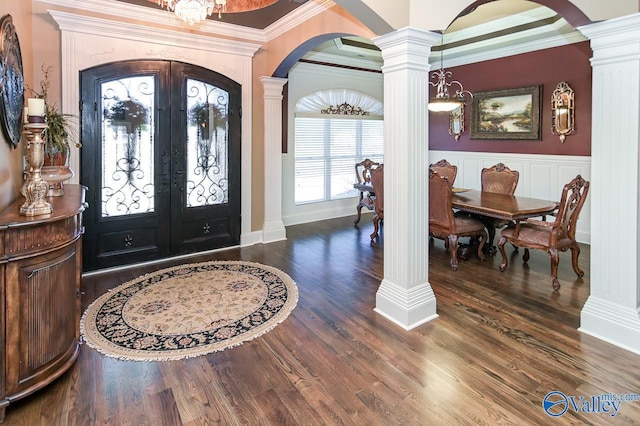 foyer with dark wood finished floors, decorative columns, arched walkways, and french doors