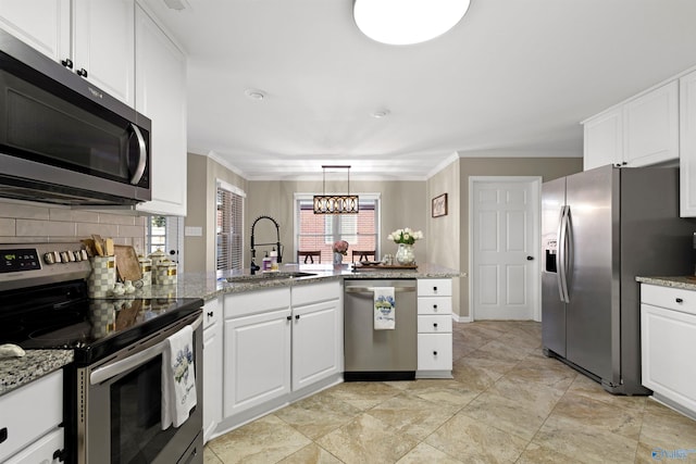 kitchen featuring ornamental molding, a peninsula, stainless steel appliances, and a sink