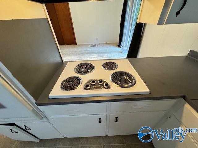 kitchen with white electric cooktop and white cabinetry