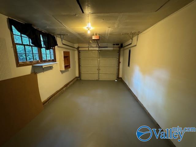 garage with baseboards and a garage door opener