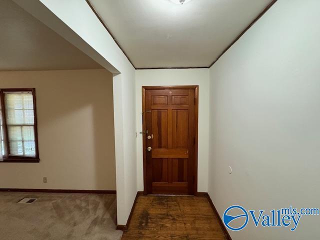 carpeted entryway with baseboards and visible vents