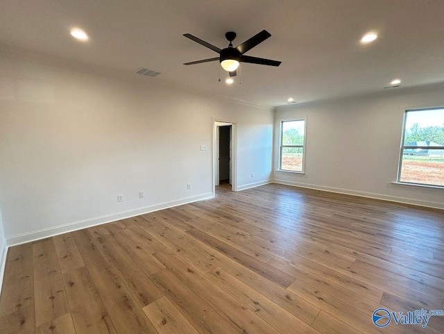 unfurnished room featuring ceiling fan, baseboards, wood finished floors, and visible vents