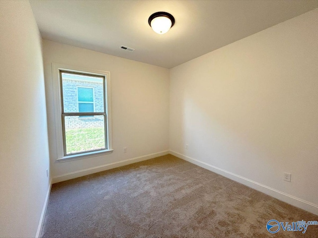 carpeted spare room featuring baseboards and visible vents