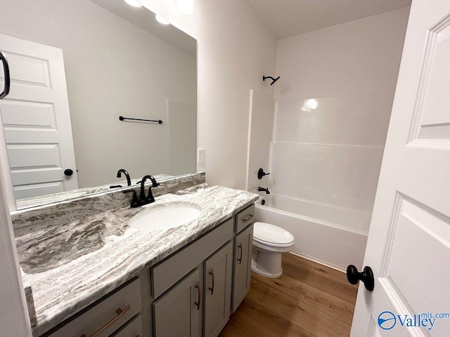 full bathroom featuring bathtub / shower combination, wood finished floors, vanity, and toilet