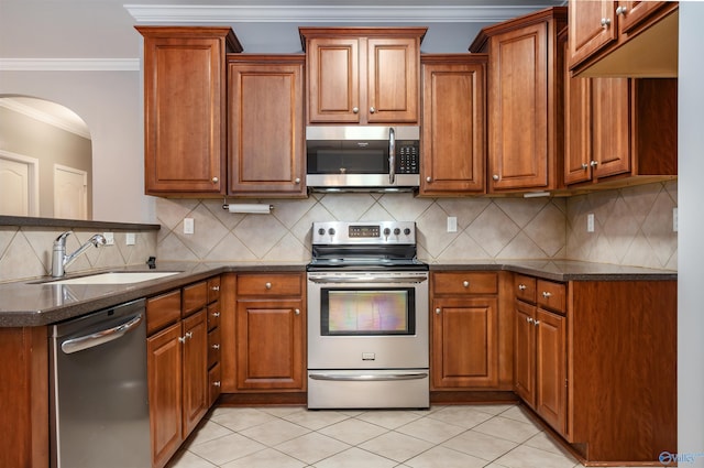 kitchen with light tile patterned flooring, appliances with stainless steel finishes, sink, backsplash, and ornamental molding