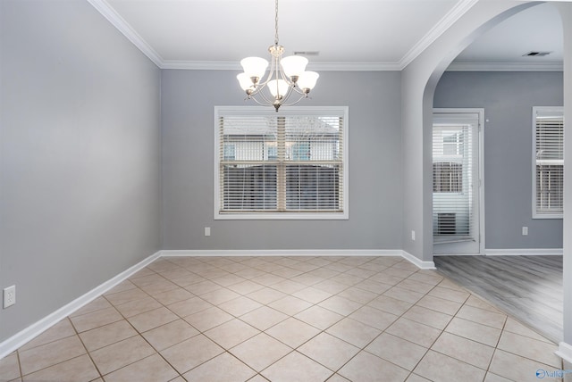 unfurnished room featuring crown molding, light wood-type flooring, and a notable chandelier