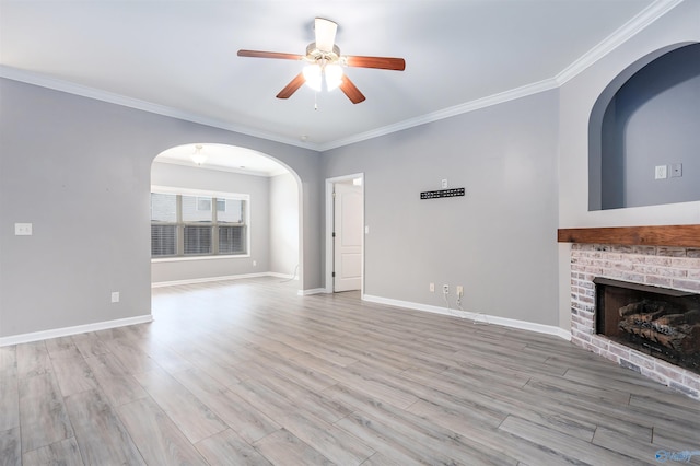 unfurnished living room with ornamental molding, light wood-type flooring, and a fireplace