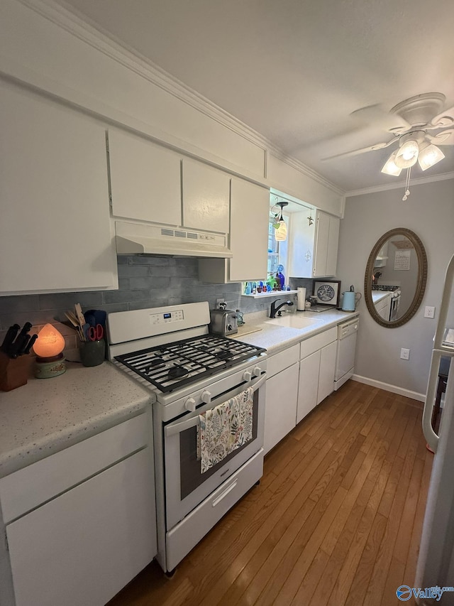 1128 Brashiers Chapel Rd, Arab, AL 35016 - kitchen with white appliances, under cabinet range hood, ornamental molding, backsplash, and light countertops