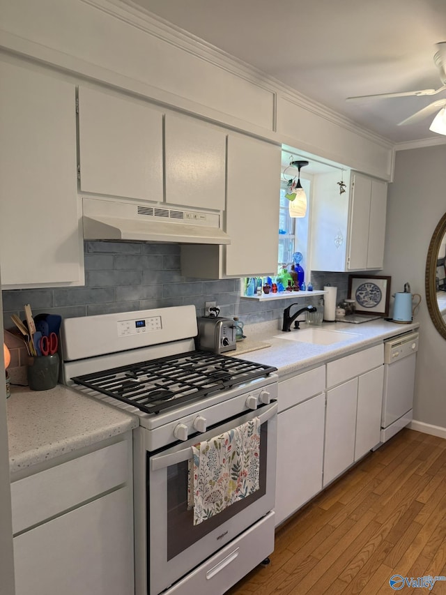 1128 Brashiers Chapel Rd, Arab, AL 35016 - kitchen with white appliances, under cabinet range hood, light wood-type flooring, light countertops, and crown molding