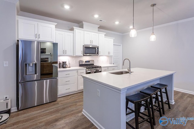 kitchen featuring sink, hanging light fixtures, an island with sink, white cabinetry, and stainless steel appliances