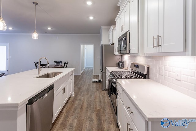 kitchen with sink, hanging light fixtures, dark hardwood / wood-style flooring, white cabinets, and appliances with stainless steel finishes