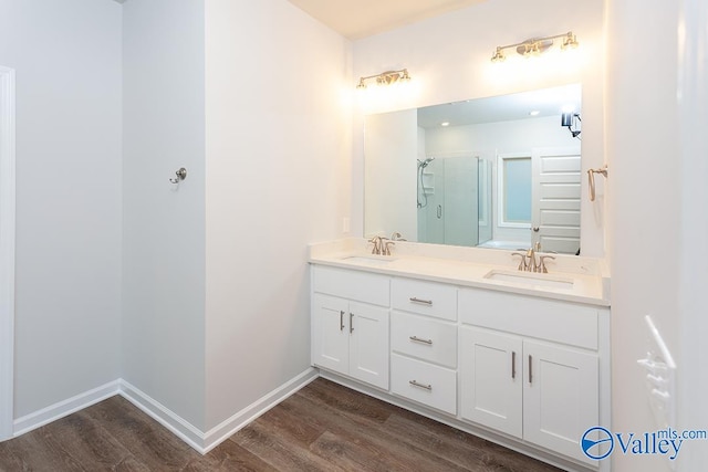 bathroom with wood-type flooring, vanity, and walk in shower