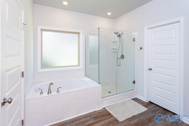 bathroom featuring plus walk in shower and wood-type flooring