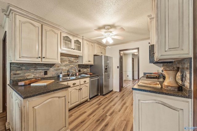 kitchen featuring cream cabinets, sink, decorative backsplash, ceiling fan, and appliances with stainless steel finishes