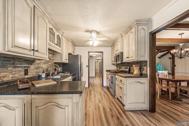 kitchen with decorative backsplash, appliances with stainless steel finishes, light wood-type flooring, kitchen peninsula, and sink