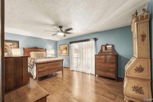 bedroom featuring hardwood / wood-style floors, a textured ceiling, and ceiling fan